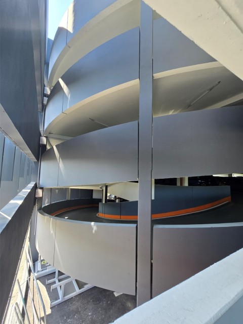 Bandeaux droits et courbes en béton gris lisse et panneaux en CCV blanc lisse